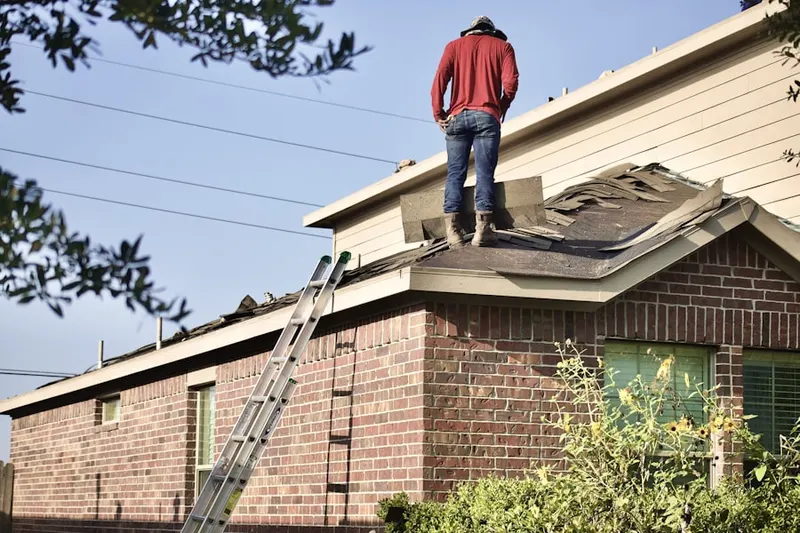 Professional roofer working on a residential roof in Reagan